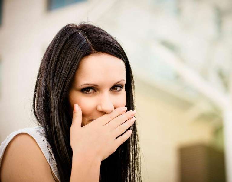woman covering her smile in boulder co