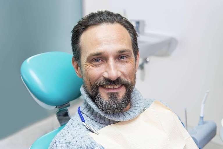 A man smiling after a dental care visit in Boulder, CO