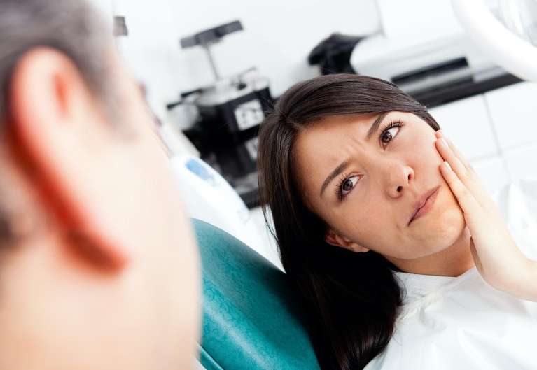 A woman in pain due to teeth sensitivity in in Boulder, CO