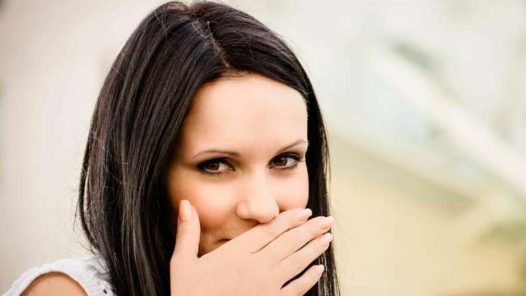 woman covering her smile in boulder co