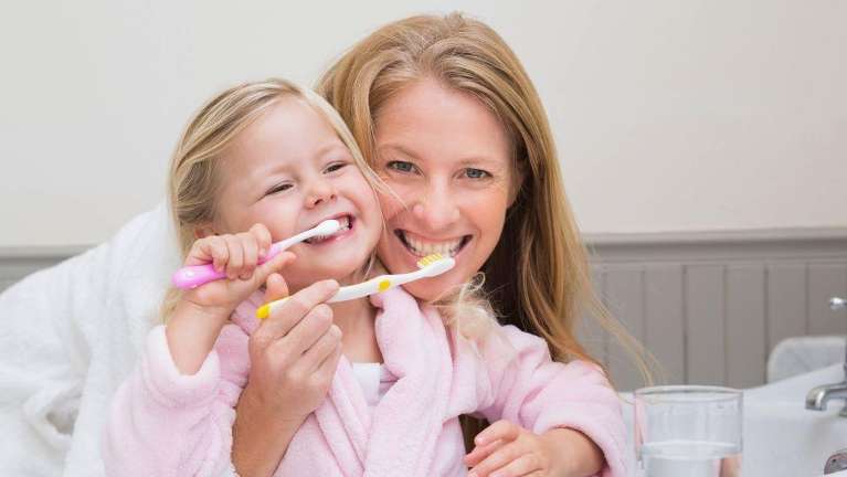 mom and daughter brushing teeth in boulder co
